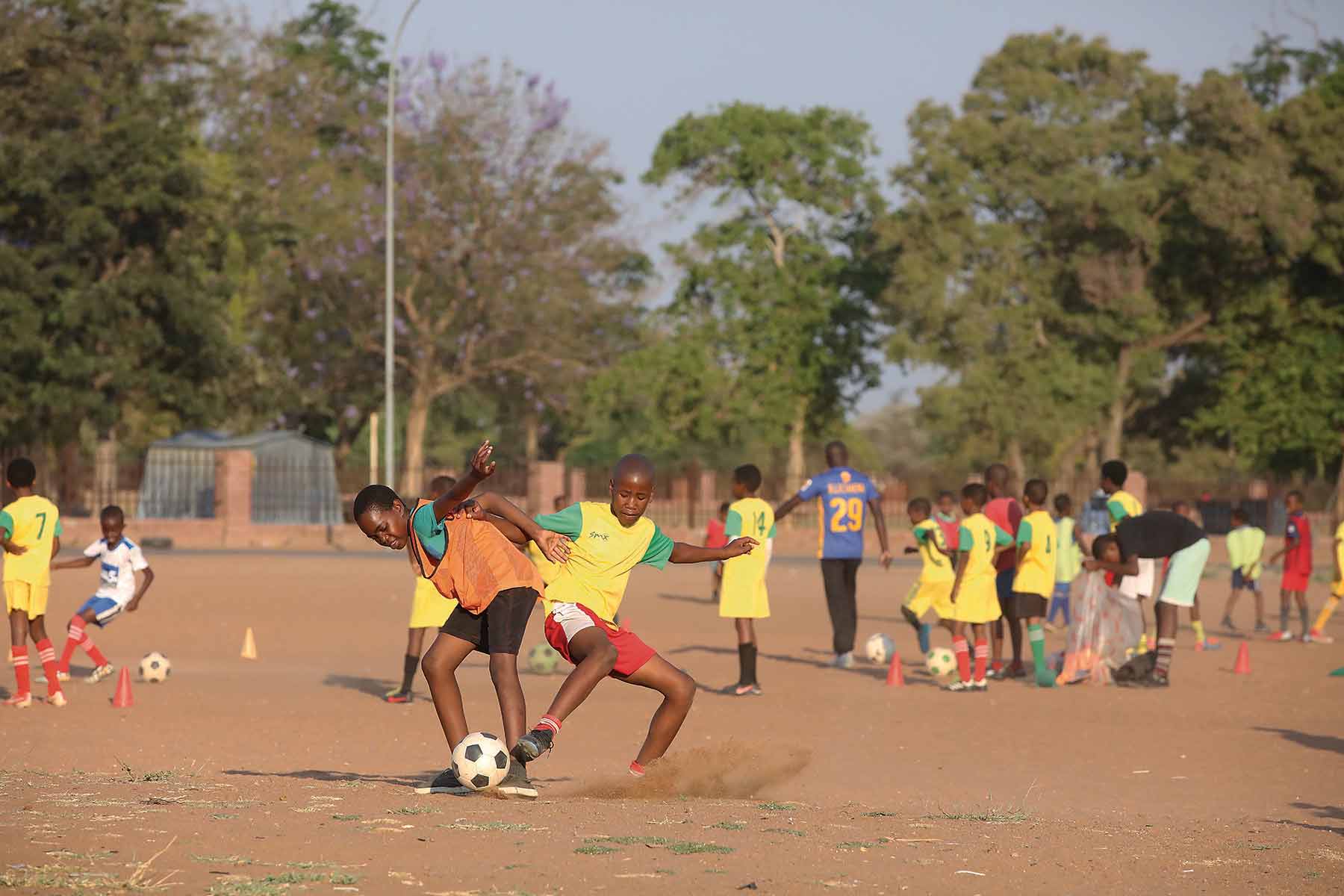 Grassroots football - children playing football on a dusty field